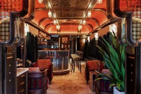 Entr&eacute;e du Bar Lounge du Golden Eagle Silk Road Express, d&eacute;cor Art d&eacute;co rouge et or