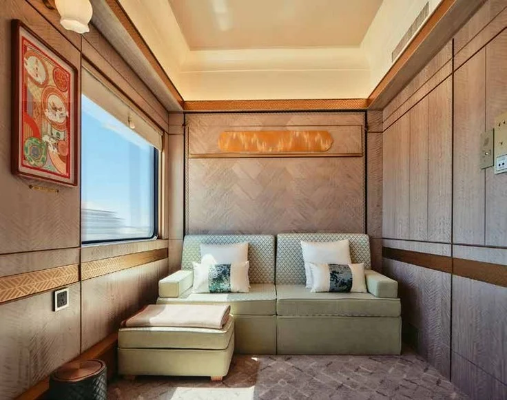 Superior Cabin du Golden Eagle Silk Road Express, salon avec canap&eacute; vert et grande fen&ecirc;tre