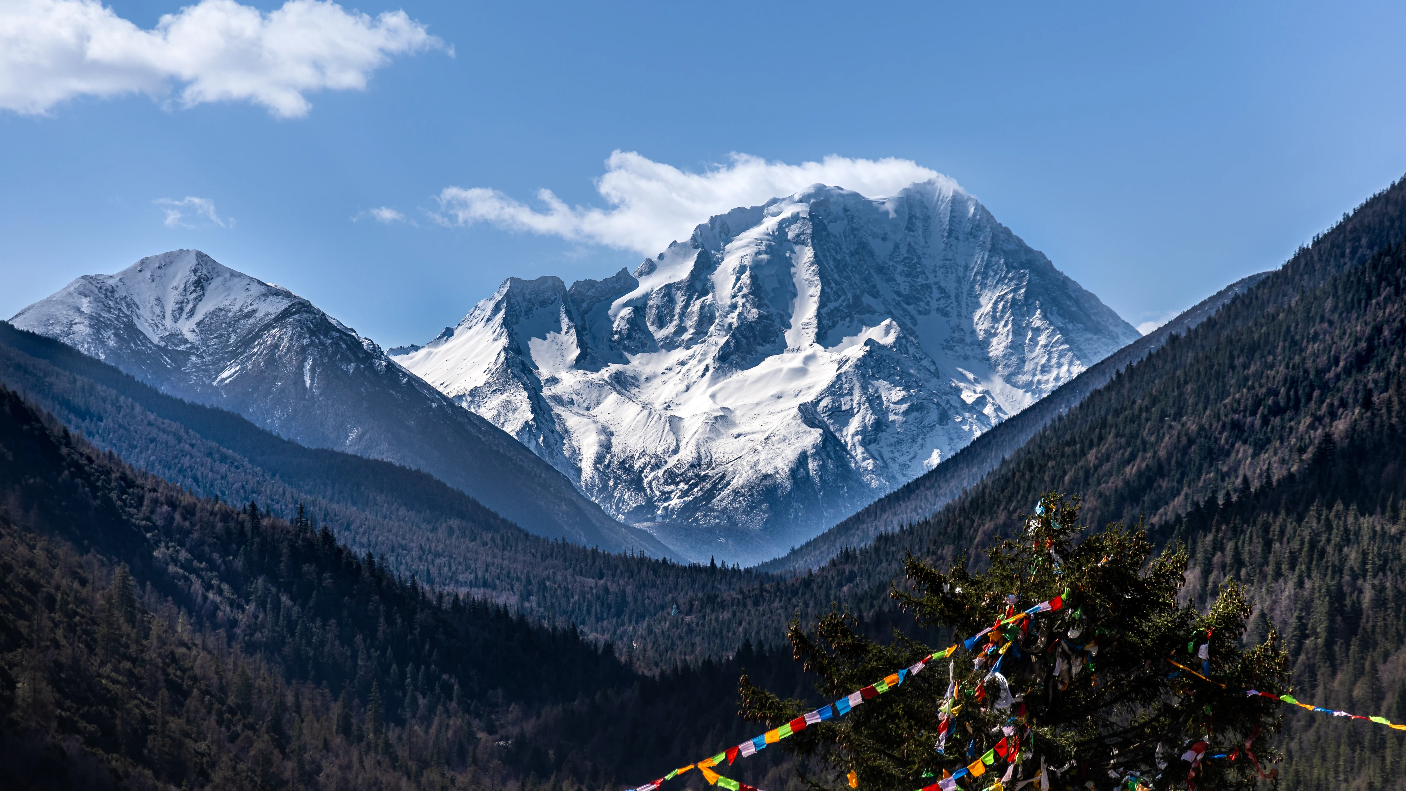 Le mont Yala enneig&eacute; avec ses drapeaux de pri&egrave;re tib&eacute;tains color&eacute;s